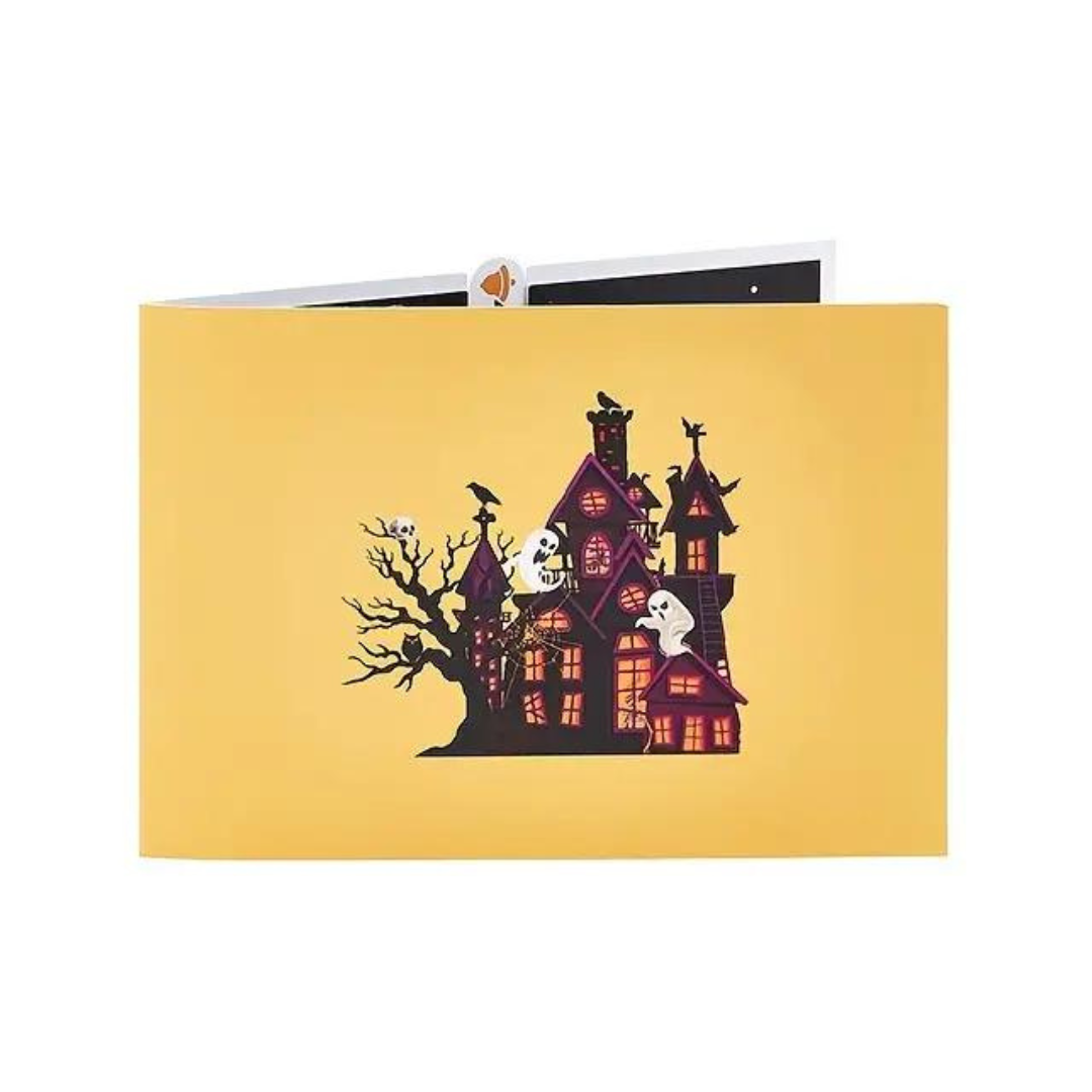 front of the haunted house pop up card, yellow face with a picture of a haunted house with ghosts