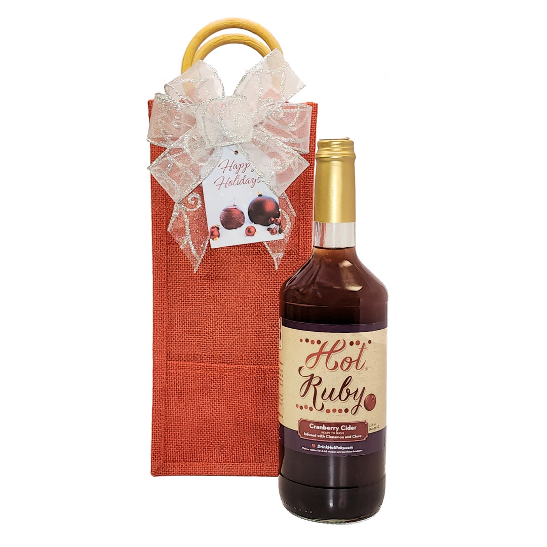 red jute bag with silvery bow and tag with a bottle of hot ruby cranberry cider