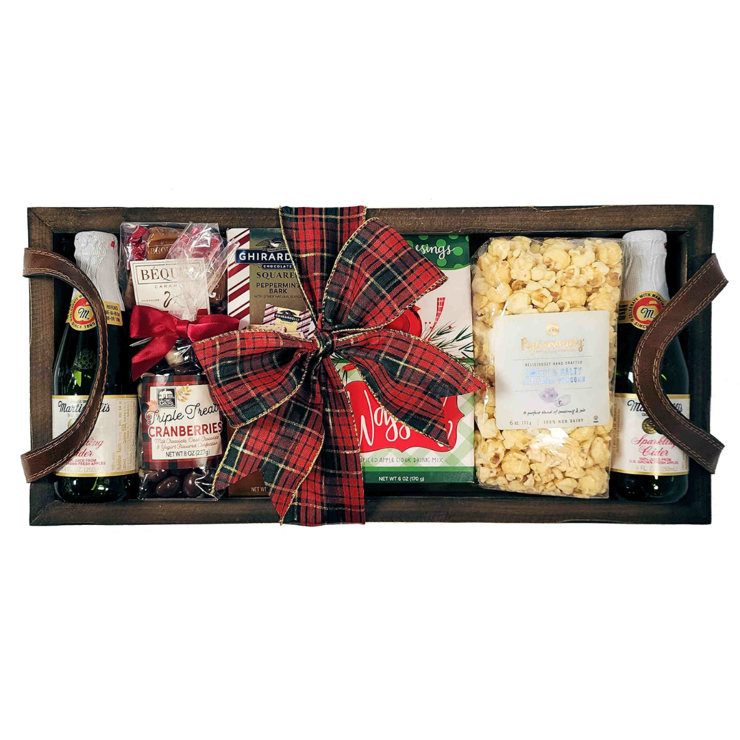 wood tray with apple cider, wassail mix, caramels, chocolates and popcorn, tied with a red and green ribbon