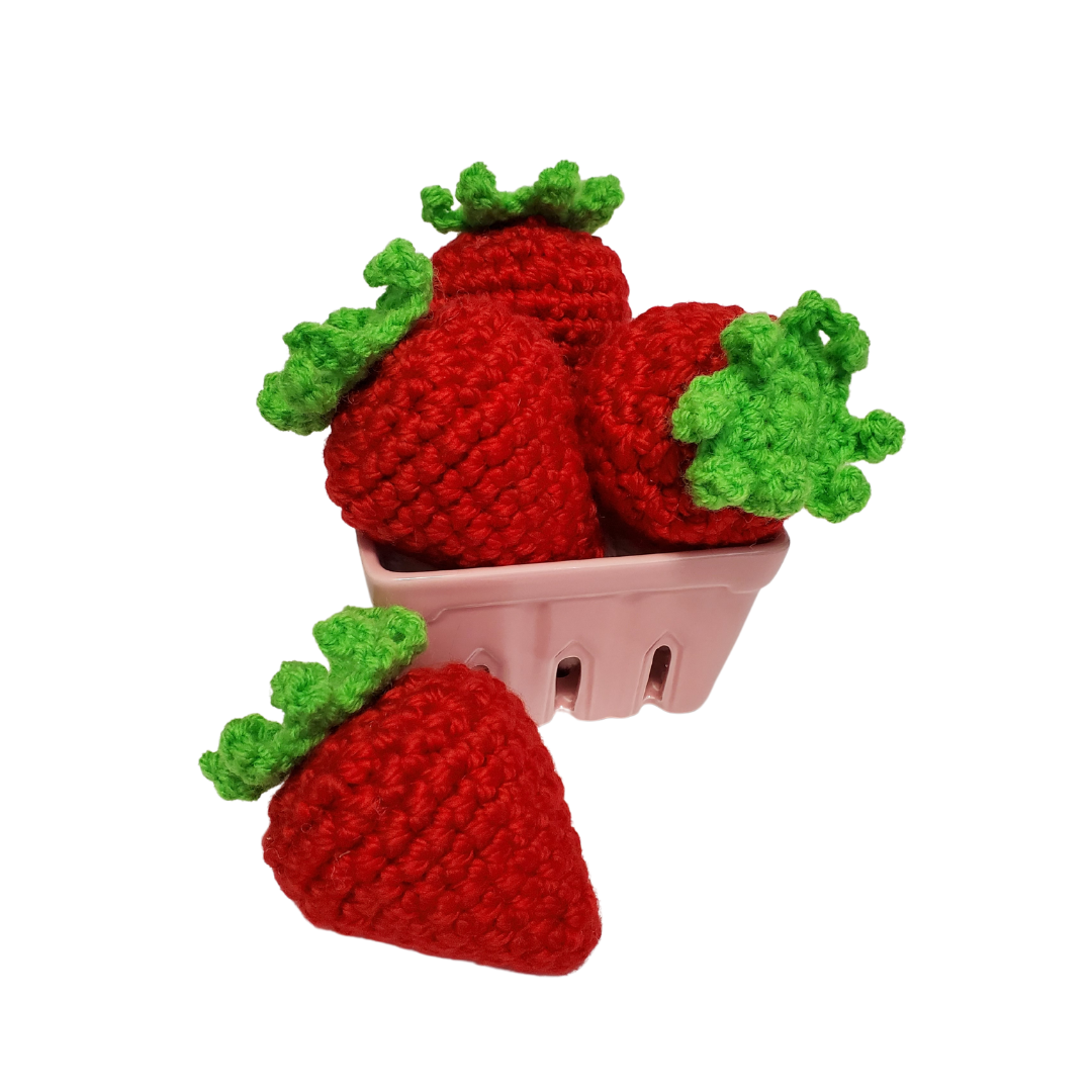 four red catnip toy strawberries in a pink berry basket