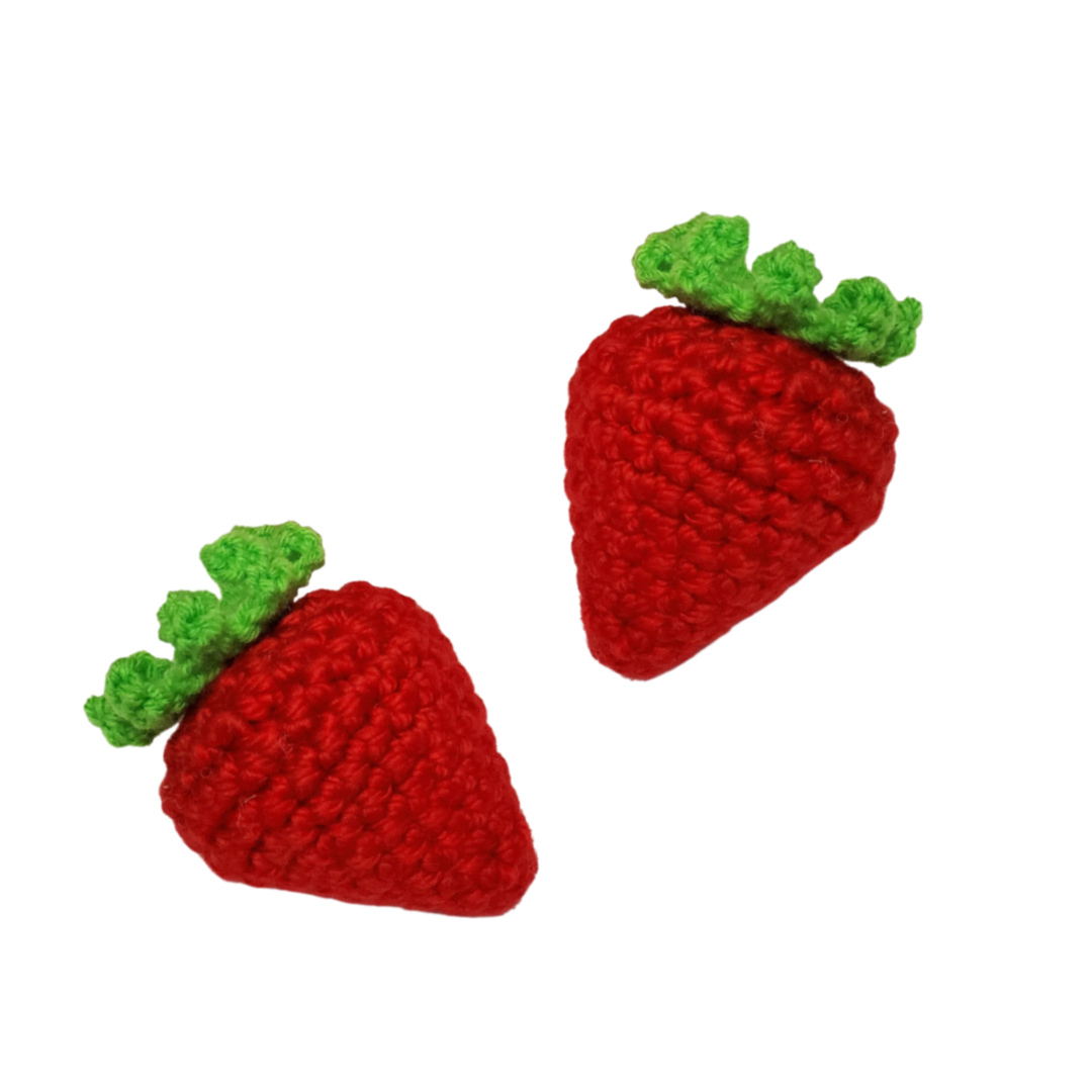 two red crocheted strawberry catnip toys