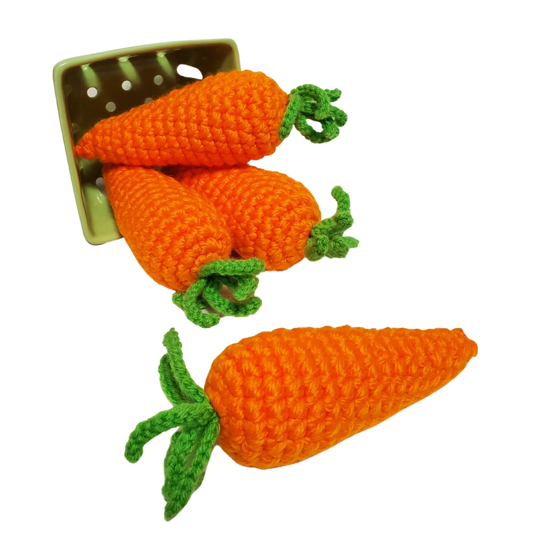 four orange crocheted catnip carrots falling out of a berry basket