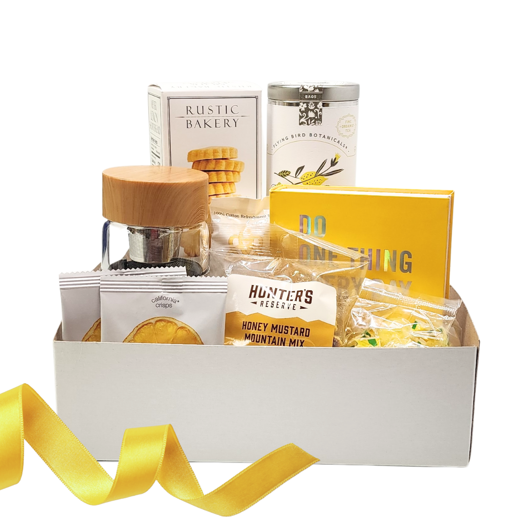 white gift box with cookies, tea, tea infuser, journal, crispy lemon slices, honey mustard mountain mix and lemon drops 