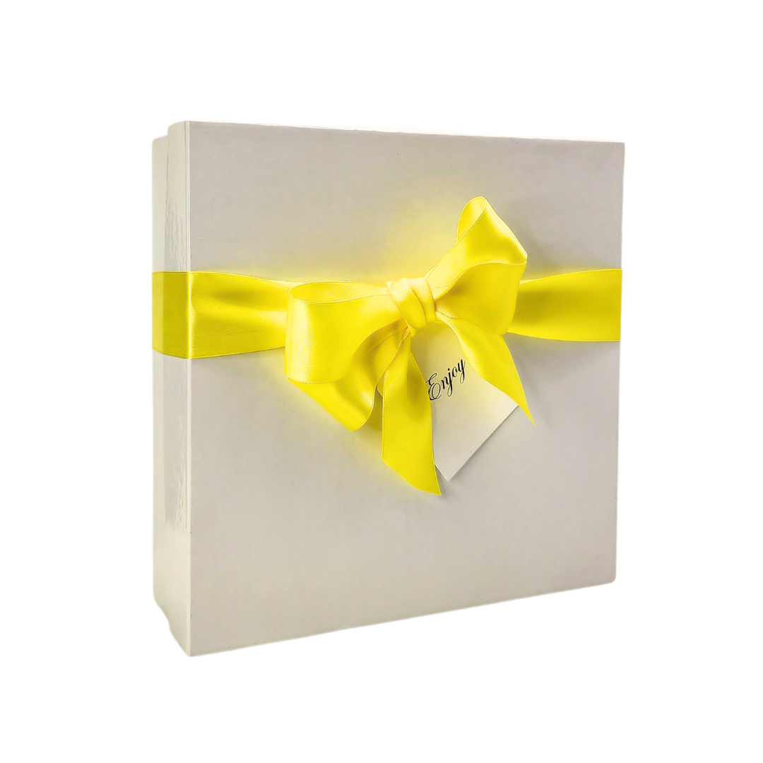square white gift box with a yellow ribbon and a tag that say "Enjoy"