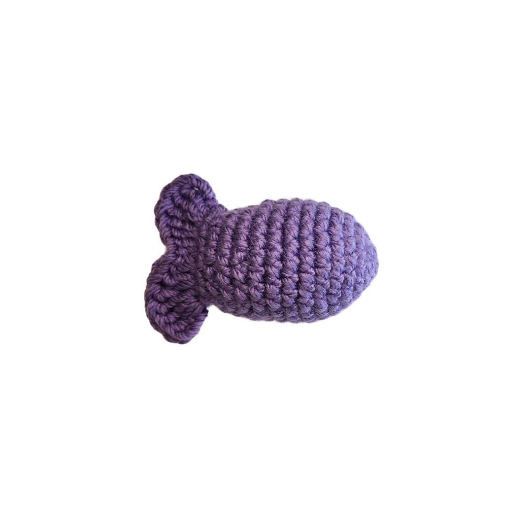 Fishy Catnip Toy: A purple knitted fish toy designed for cats, handmade with durable yarn, filled with organic catnip and silver vine, promoting playful activity.