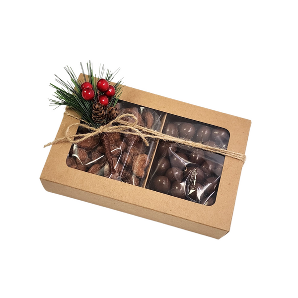 Gourmet Treats in a Holiday Gift Box featuring chocolate pretzel balls and honey roasted cashews, adorned with a pinecone and berries. Ideal for festive gifting.