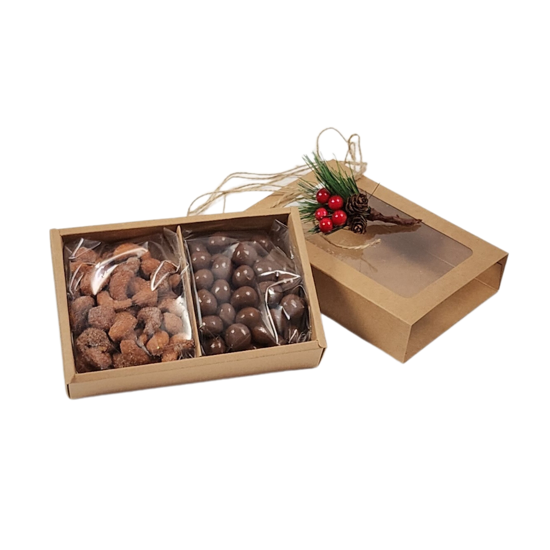 GOURMET TREATS IN A HOLIDAY GIFT BOX featuring chocolate pretzel balls and honey roasted cashews in a festive kraft slider box with holiday embellishments.