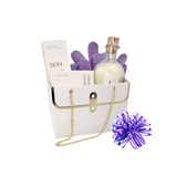 Lavender Weekend Retreat Spa Set featuring bath salts, exfoliating gloves, and soap, elegantly packaged in a white bag with a purple and blue bow.