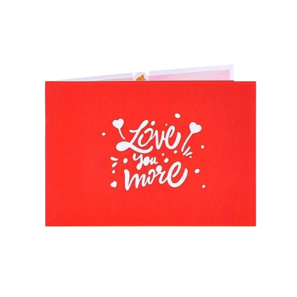 Love You More Pop Up Card featuring red and white design, includes a blank note card, crafted from recycled paper, measuring 7 x 5.