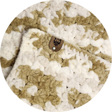 COZY CRASH PAD - CALICO CREAM: Close-up of a plush, crocheted cat pad with a leather tag featuring a cat illustration, ideal for protecting furniture and lining carriers.