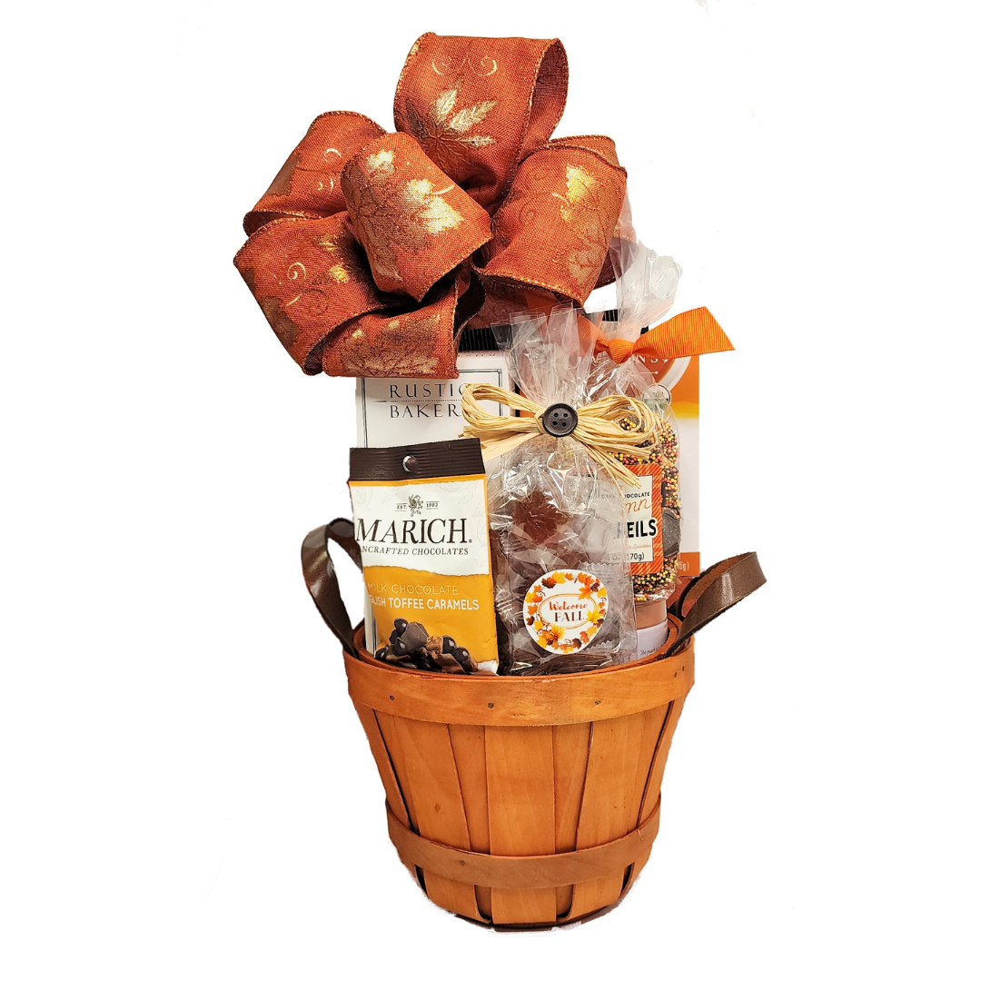 WELCOME FALL SWEET GIFT BASKET showcasing chocolate caramels, candies, and popcorn, adorned with a large orange bow and festive enclosure card. Perfect for autumn celebrations.