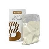 White Hot Chocolate in a bag beside a white and gold package, showcasing a creamy mix for indulgent cups of hot cocoa.